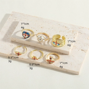 Golden Evil Eye rings set with enamel and zircon details on a stone display