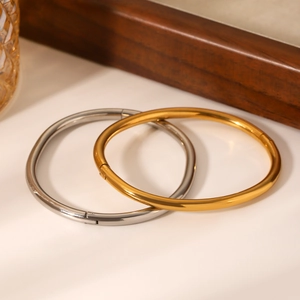Minimalist gold and silver polished stainless steel bangles set on a clean white background
