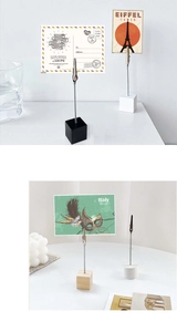 Detail of minimalist wooden base photo holder with a silver wire clip on a desk