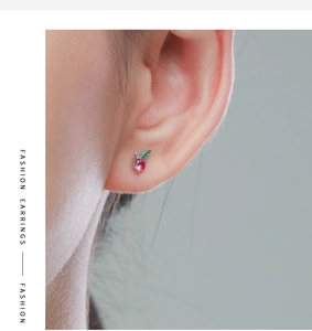 On-ear view of small silver cherry stud earrings with pink and green stones
