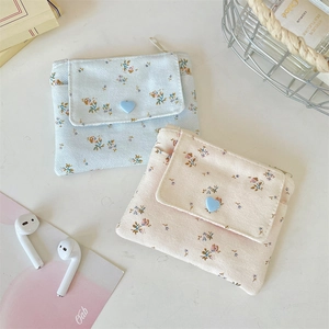 Close-up of floral canvas wallets with heart buttons and dual storage compartments