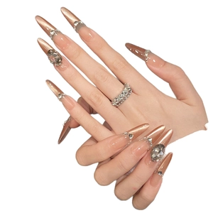 Long almond press-on nails with champagne gold glitter and elegant rhinestones
