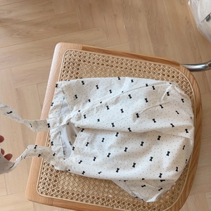 Sac fourre-tout en coton gris clair à motifs floraux et nœuds sur une chaise