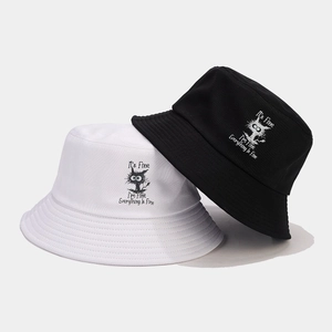 Dettaglio di cappelli alla pescatora in cotone bianco e nero con stampa di gatto