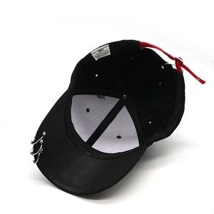 Detail of black cotton hip-hop cap showing silver metal rings and red adjustable strap