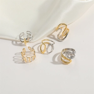 Close-up of five minimalist two-tone gold and silver adjustable rings with wave design