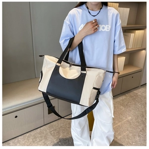 Model wearing a large capacity sports duffel bag with a stylish black and white contrast