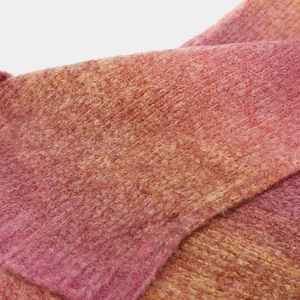 Detailed macro view of soft pink-orange gradient knit fabric with plush fuzzy texture