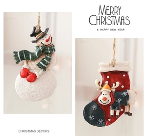 Detail of handcrafted resin snowman and reindeer stocking ornaments with rustic jute ropes