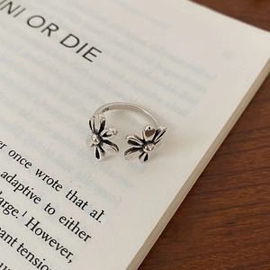 Close-up of vintage hollow flower open ring with S925 engraving on retro book