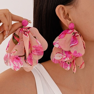 Detailed view of oversized pink chiffon flower drop earrings with layered petal design