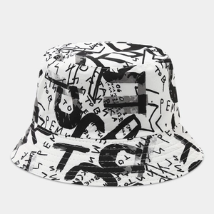 Detail view of double-sided bucket hat featuring black letter graffiti on white canvas