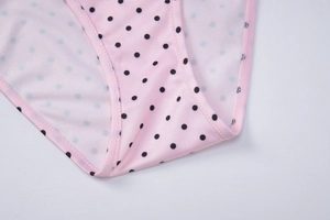 Detailed macro view of pink polka dot bikini bottoms showing stitching and fabric texture