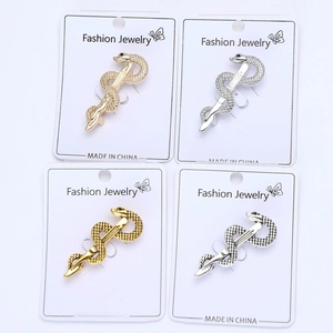 Macro detail of snake-shaped brooches in gold and silver with zircon micro-paving