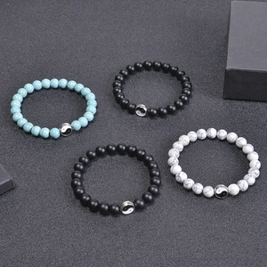 Yin Yang 8mm matte stone and white turquoise beaded bracelet set on dark textured surface