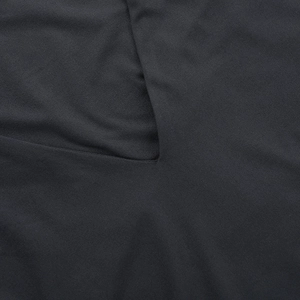 Close-up of high-quality sewing and edge binding on a slim-fit black knitted V-neck top