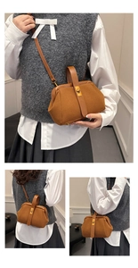 Detail view of the vintage suede caramel shell bag with a gold rotating metal lock