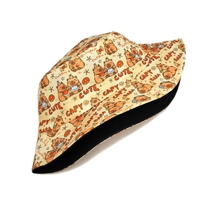 Detail view of the yellow capybara bucket hat with black lining and cartoon print