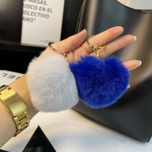 Detail of blue and grey heart-shaped plush keychains with golden metal rings