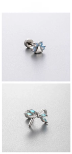 Detail of blue opal cat paw and bow stud earrings in polished surgical steel