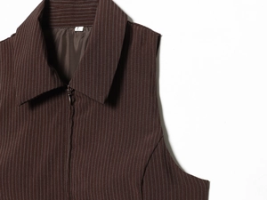 Détail du haut marron rayé sans manches avec col zippé et texture de tissu en maille