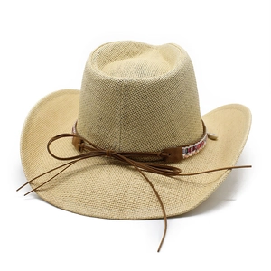 Detail eines gewebten Stroh-Cowboyhuts mit Ethno-Band, Muschel-Anhängern und Krempe