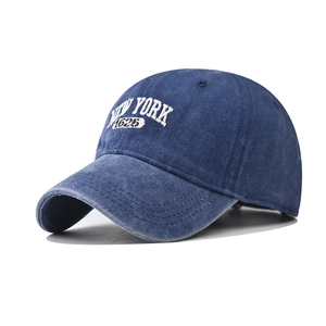 Macro view of white NEW YORK 1625 embroidery on washed navy blue cotton baseball cap