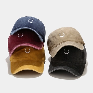 Collection of washed cotton baseball caps with embroidered smile face in five vintage colors