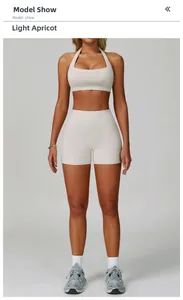 Front view of women's light apricot halter neck yoga set with high waist fitness shorts