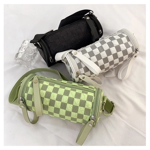 Detail view of cylinder crossbody bags with checkerboard patterns and wide straps
