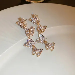 Sparkling zircon butterfly tassel earrings in gold plating with long linear drop design
