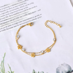 Double-layered gold titanium bracelet with floral charms and heart-shaped zirconia accents