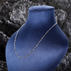Polished silver link necklace displayed on a mannequin against dark rock background