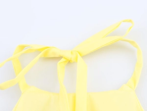 Detailed macro view of yellow halter neck tie in premium textured fabric for women