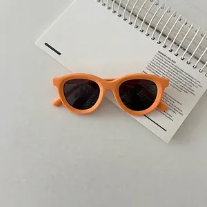 Detail of round orange polarized kids sunglasses on a notebook showing matte texture
