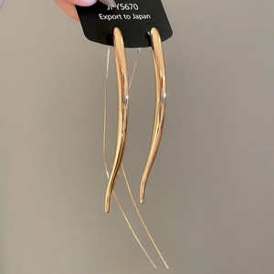 Macro shot of polished gold-plated teardrop earrings with a sleek mirror-like finish