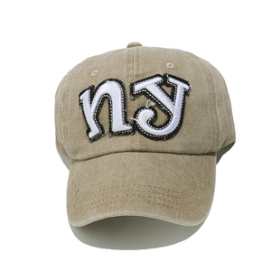 Close-up of the vintage khaki cotton fabric and white NY embroidery on baseball cap