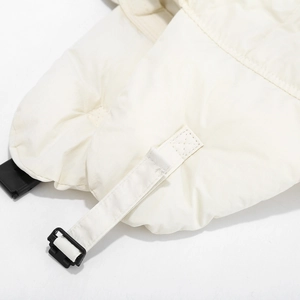 Close-up of windproof fabric and black buckle on cream winter trapper hat