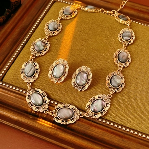 Macro shot of vintage golden resin oval earrings and necklace set on a wood frame