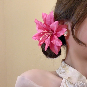 Detail of pink fabric lily flower hair clip showing realistic petal textures and stamen