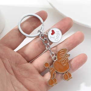 Detailed close-up of metal poodle keychain with I Love Dogs charm held in hand