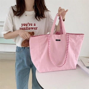 Close-up of pink canvas tote bag featuring stylish plaid straps and large capacity design