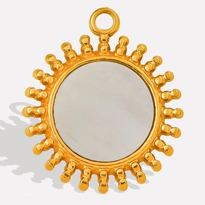 Macro shot of gold sunburst pendant with white shell inlay and 304 stainless steel texture