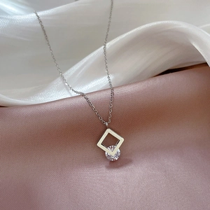 Macro shot of silver square pendant with round zircon on elegant silk background