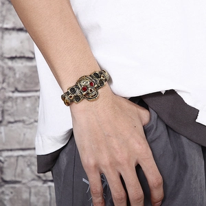 Gros plan du bracelet punk tête de mort avec yeux rubis sur chaîne dorée vintage
