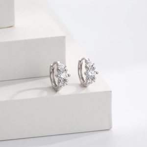 Detailed close-up of a pair of S925 silver hoop earrings with three inset white zircons