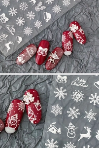 Detailed relief of 3D Christmas nail stickers with snowflakes and reindeer on red nails