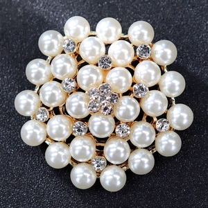Detailed view of luxury gold brooch featuring elegant white pearls and sparkling crystals