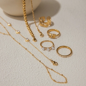 Elegant gold titanium steel jewelry set featuring pearl rings and zircon necklaces