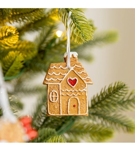 Detail of Christmas gingerbread house ornament hanging on tree with festive lights